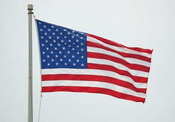 Fototapeta premium American flag waving in the wind with thirteen red and white stripes, blue field with fifty white stars, vibrant and dynamic appearance, shiny fabric