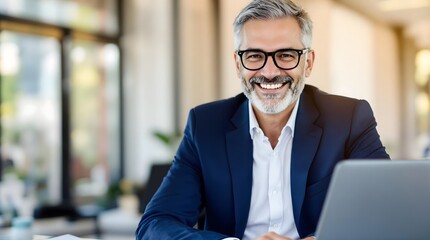 Smiling Businessman in Office Setting with Laptop.