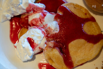 Breakfast plate with pancake and strawberry jam whipped cream