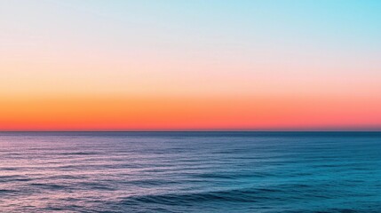 Obraz premium A serene seascape at sunset, showcasing vibrant hues of blue, pink, and orange reflecting on calm waters.