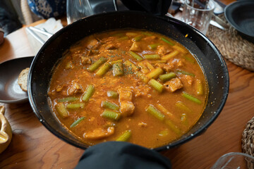 Making a typical Valencian paella with green beans, chicken, and rabbit, Spain