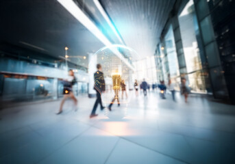 Modern commercial environment in Hong Kong. Blurred figures suggest bustling business activity in a bright, spacious, and futuristic building.