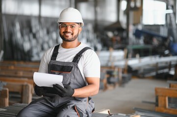 Portrait of cheerful young worker wearing hardhat at modern factory