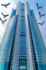 Naklejka premium Modern Skyscraper with Birds in Flight - Urban Architecture and Nature