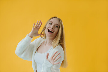 Cheerful Young Woman Posing Against Vibrant Yellow Background with Enthusiastic Expression
