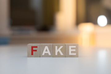 Wooden Cubes on the Table with Fake Written on Them