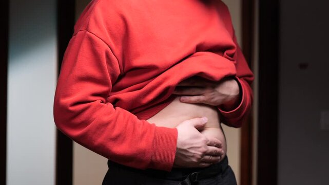 Man suffering from abdominal pain, touching belly with hands