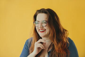 Portrait of a Happy Woman Smiling Against a Bright Yellow Background