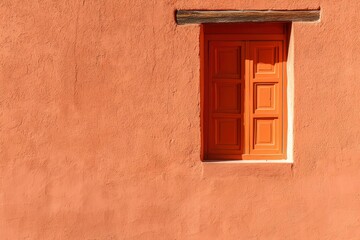Window in adobe wall provides architectural detail in warm sunlight