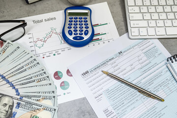 1040 U.S. income tax form with pen keyboard calculator dollar money on desk