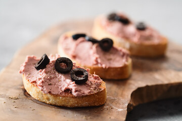 Ciabatta with meat paste on olive wowod board