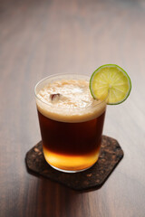 Espresso tonic in simple glass on walnut wood table with copy space