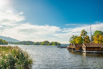Scenic view of Ammersee lake in Bavaria, Germany, with traditional wooden boathouses, lush nature,...