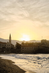 Fototapeta premium View of the old town with fortress and citadel at dawn. The coast of the Adriatic Sea. Budva, Montenegro in the morning sun.