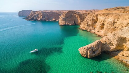 Boat floats on clear water by cliffs in sunny, secluded tropical coast