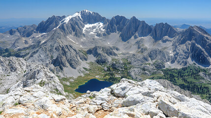 Majestic Mountain Vista: An expansive panorama unveils a rugged mountain range under a clear, blue sky, revealing a pristine lake and snow-capped peaks.