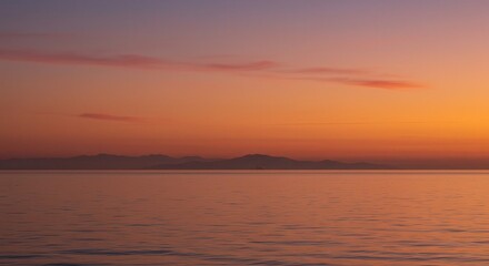 Naklejka premium Calm Sea at Sunset with Mountains and Colorful Orange Sky