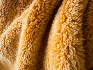 Soft and cozy golden fur fabric drapes elegantly over a surface