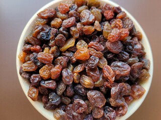 Yummy pile of dried raisins on a dark background.