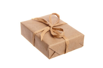 Small rectangular gift box wrapped in brown kraft paper and tied with a rustic twine bow. Eco-friendly, minimalist packaging isolated on a white background
