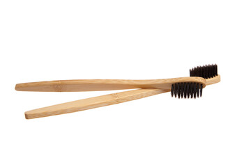 Two eco-friendly bamboo toothbrushes with black bristles, crossed over each other. Sustainable, biodegradable, and plastic-free choice for oral hygiene