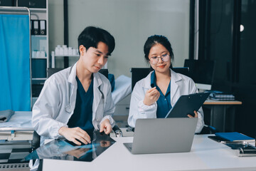 Fototapeta premium Positive doctor working on laptop in medical office, portrait.