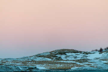 A bright orange glow colours the golden hour sky that serves as a dramatic background for the...