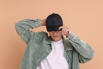 Man in stylish baseball cap on beige background. Mockup for design