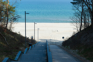 Scenic Stairway Leading to a Sandy Beach with Blue Sea and Sky in Jastrzębia Góra