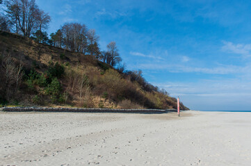 Eroded Sand Cliffs with Forest Above a Sandy Beach in Jastrzębia Góra on a Sunny Day