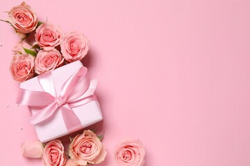 Beautiful composition with pink roses and gift box on color background