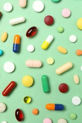 Various pills on green background