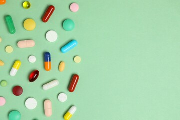 Various pills on green background