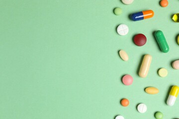 Various pills on green background