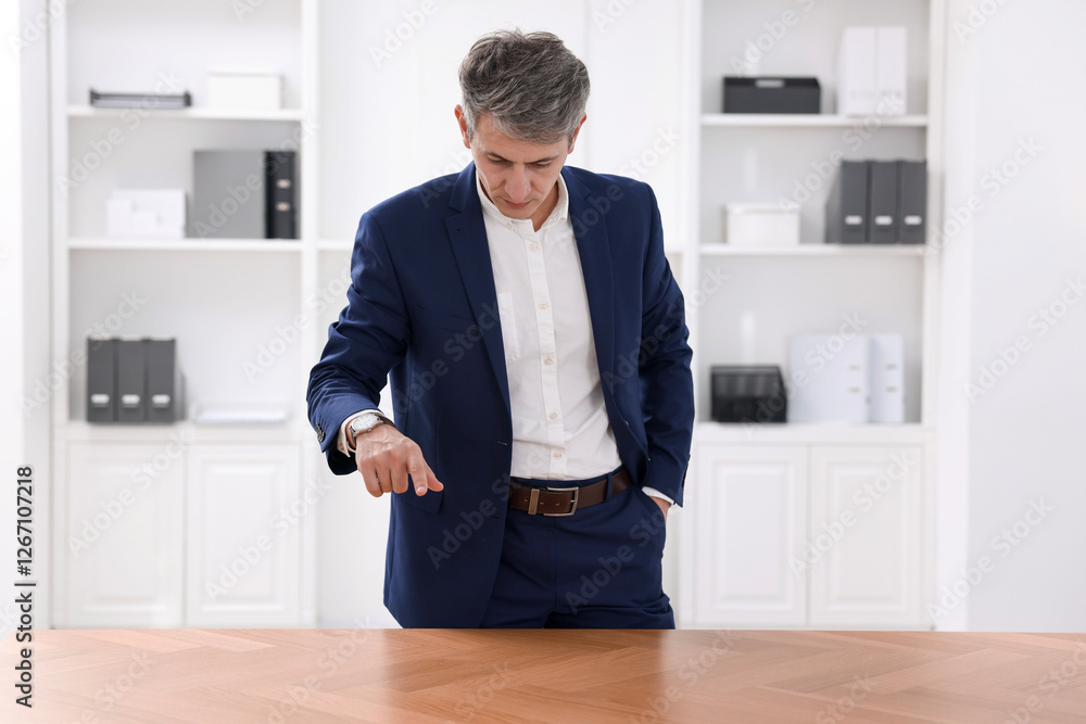 Poster man pointing at something on desk in office