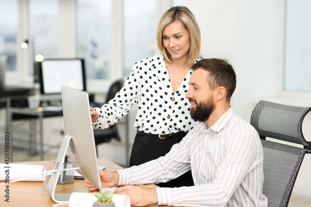 Poster technicians making digital engineering drawing on computer at desk in office