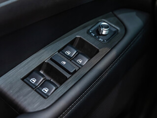 Side door buttons: window, mirror adjustment buttons, door lock. Car inside..
