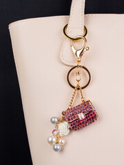 close up of beautiful shiny pink  rhinestone handbag keychain on white bag