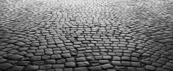 Old historical cobblestone pavement in perspective as background. vintage retro aged square cobble stone paving backdrop. Stone pavement texture. Abstract background of old cobbled stone pavement.