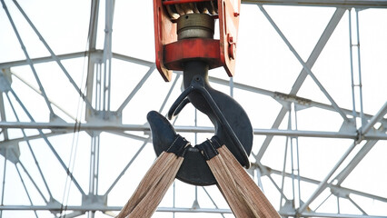 Close-up of a crane hook against a blue sky background