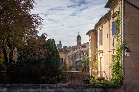 A view of Uz&egrave;s' charming streets at sunrise, as golden light bathes the historic stone facades, revealing the timeless beauty of this picturesque French town