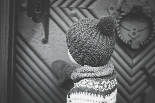 Curious boy outside norwegian stabbur in black and white. 