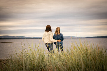 Fototapeta premium Mother and daughter together at the beach enjoying the view