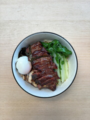 A bowl of beef ribs noodles with vegetables.