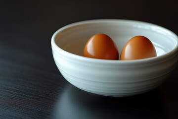 Two brown eggs in a white bowl placed on a dark surface in a cozy kitchen setting