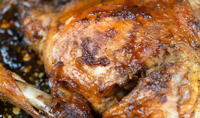 Roasted spicy chicken leg with skin in the oven pan, close-up. Natural collagen, healthy food.