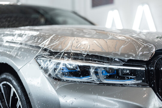 Wrap the hood of a car with protective ppf film. Detailing service. Protecting a car from scratches