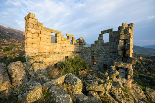 Sunlit Ancient Stone Ruins and Rugged Landscape at Lake Bafa, Turkey