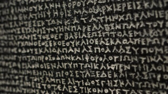 The Rosetta Stone, ancient stele inscribed with three scripts, key to deciphering Egyptian hieroglyphs. Macro close-up footage. Exhibit in museum.