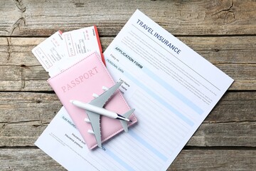 Medical tourism. Travel insurance application form, plane model, passport and flight tickets on...